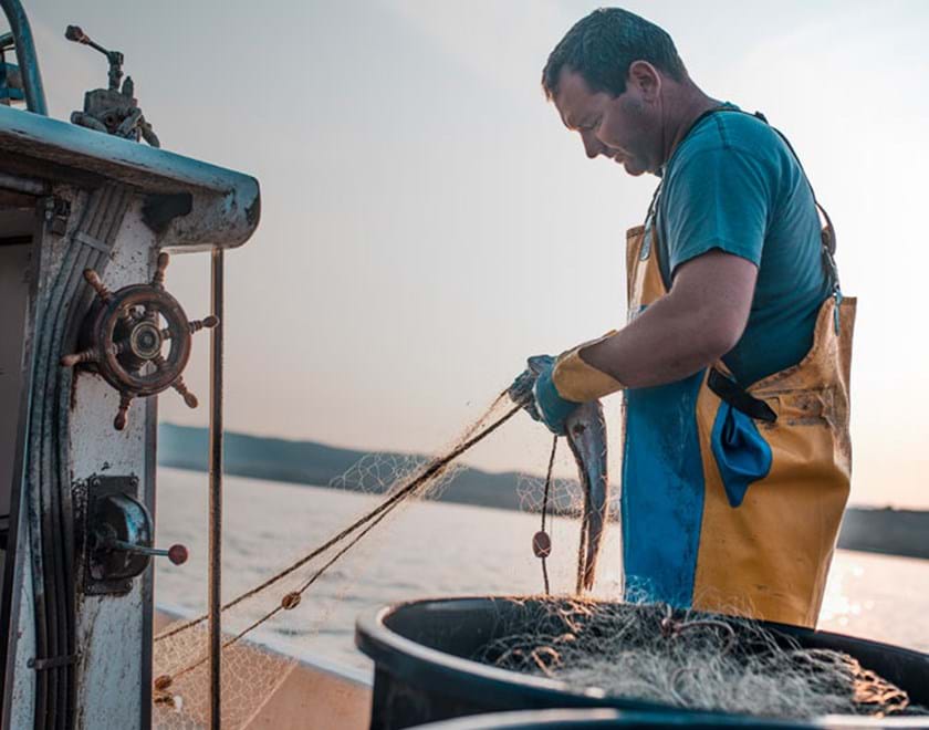 A man working with fishing nets at sea
