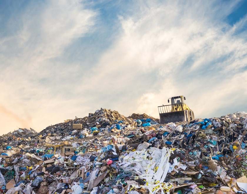 Bulldozer at a landfill site full of plastic