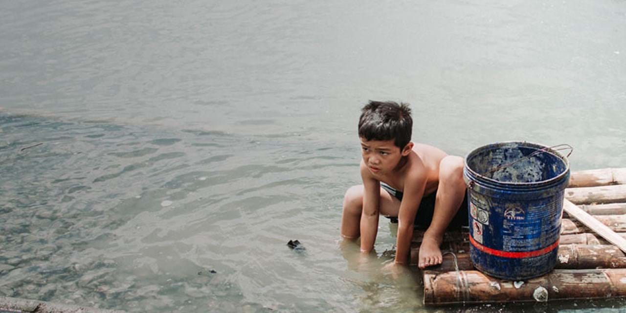 Boy washing in polluted water